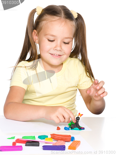 Image of Little girl is playing with plasticine