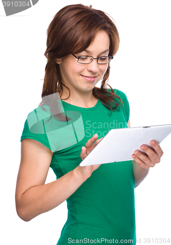 Image of Young cheerful woman is using tablet