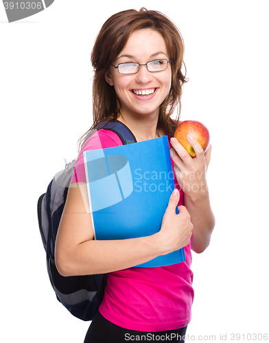 Image of Young student girl is holding book and apple