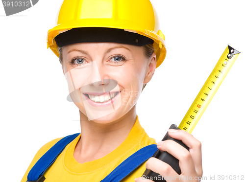 Image of Young construction worker with tape measure