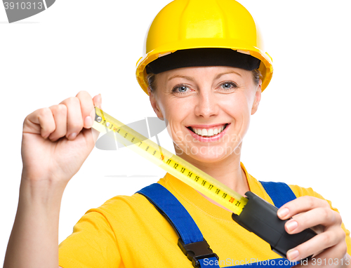 Image of Young construction worker with tape measure