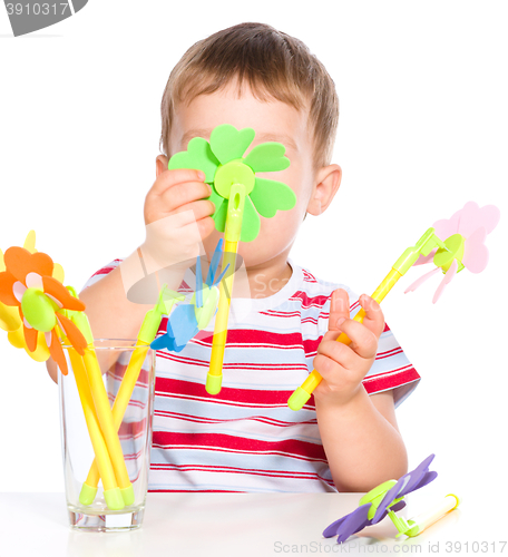 Image of Boy is playing with artificial flowers toys