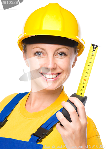 Image of Young construction worker with tape measure