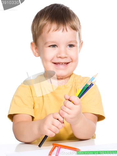 Image of Little boy is playing with color pencils