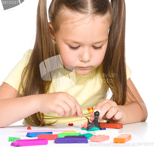 Image of Little girl is playing with plasticine