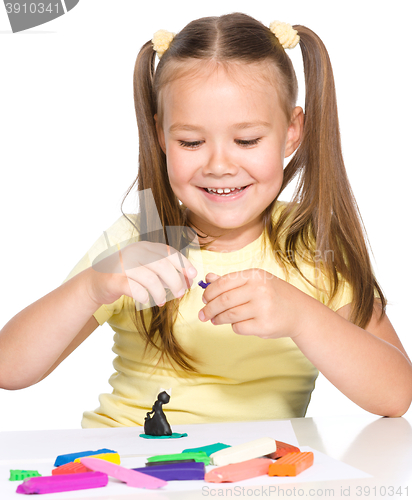 Image of Little girl is playing with plasticine