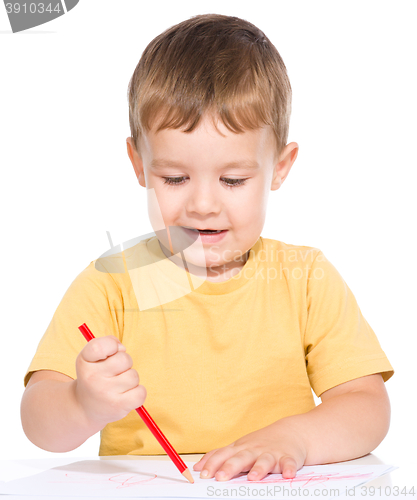 Image of Little boy is drawing using color pencils