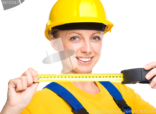 Image of Young construction worker with tape measure