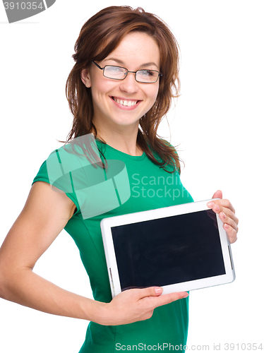 Image of Young cheerful woman is showing blank tablet