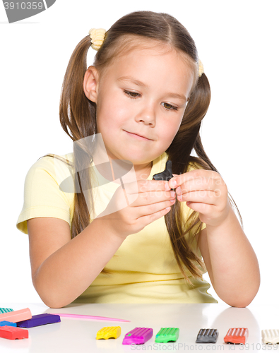 Image of Little girl is playing with plasticine