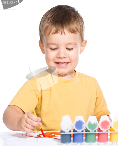 Image of Little boy is playing with paints