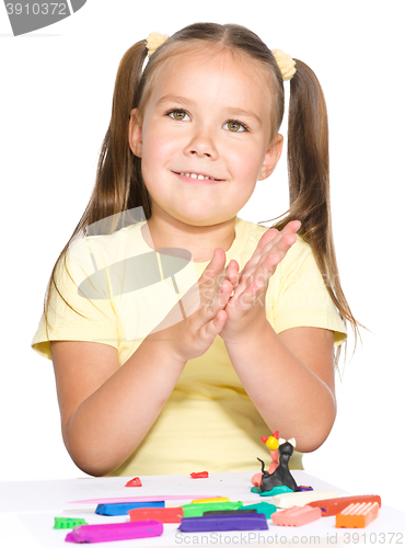 Image of Little girl is playing with plasticine