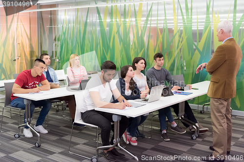 Image of teacher with a group of students in classroom