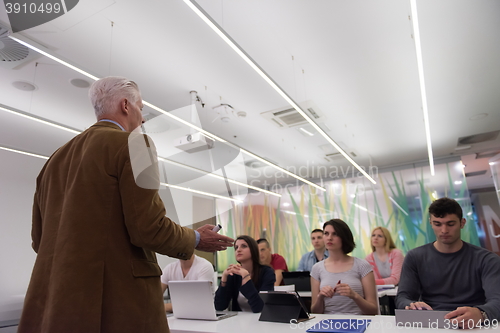 Image of teacher with a group of students in classroom