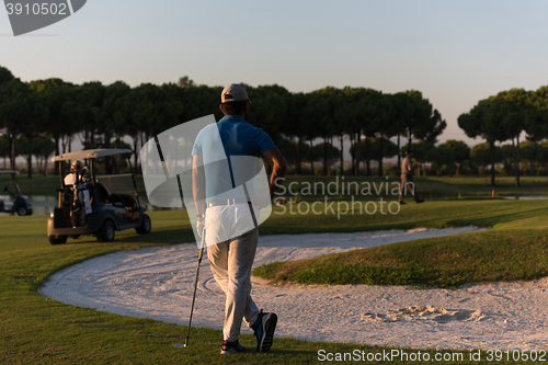 Image of golfer from back at course looking to hole in distance