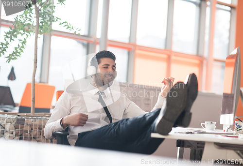 Image of relaxed young business man at office