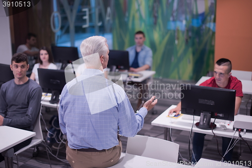 Image of teacher and students in computer lab classroom