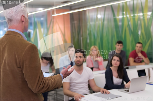 Image of teacher with a group of students in classroom