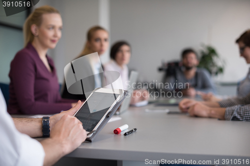 Image of close up of  businessman hands  using tablet on meeting