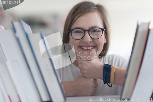 Image of portrait of famale student selecting book to read in library