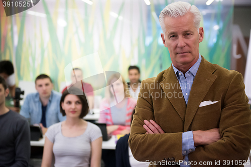 Image of portrait of  teacher with students group in background