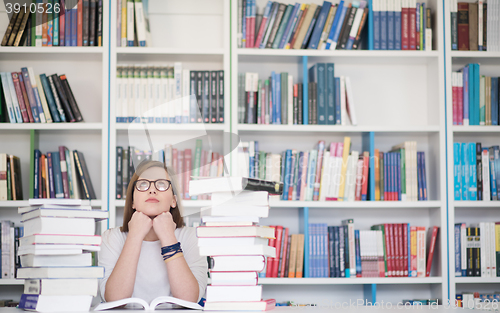 Image of female student study in library, using tablet and searching for 