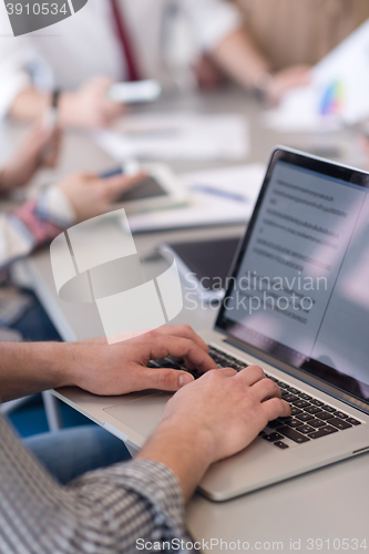 Image of close up of business man hands typing on laptop with team on mee