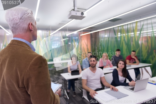 Image of teacher with a group of students in classroom