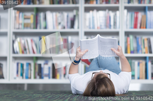 Image of female student study in library, using tablet and searching for 