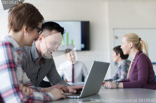 Image of young business couple working on laptop, businesspeople group on