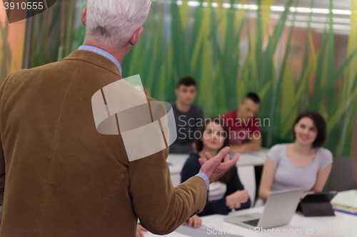 Image of teacher with a group of students in classroom