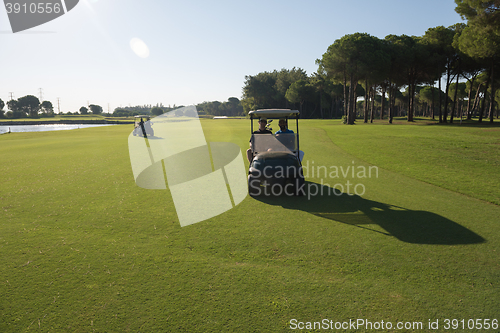 Image of golf players driving cart at course