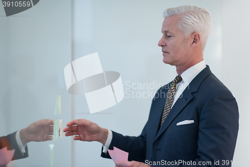 Image of senior business man making plans with sticker