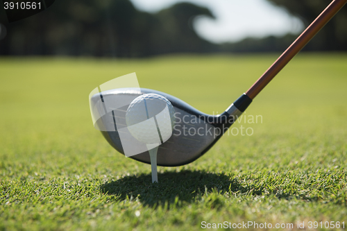 Image of golf player placing ball on tee