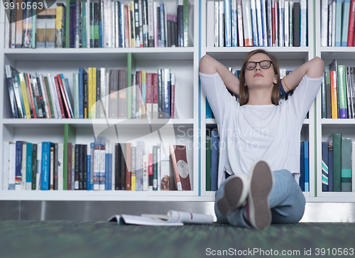 Image of female student study in library, using tablet and searching for 