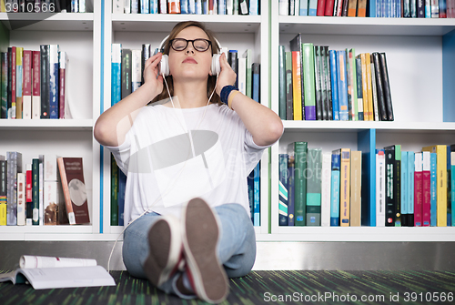 Image of female student study in library, using tablet and searching for 