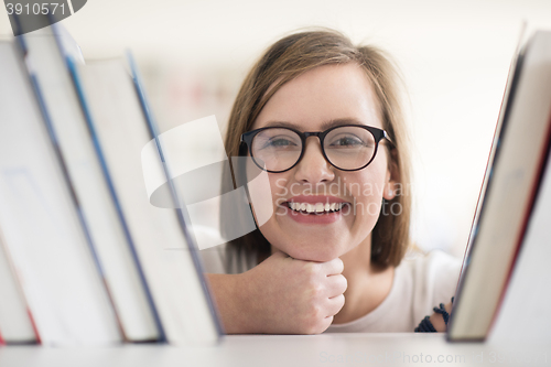 Image of portrait of famale student selecting book to read in library