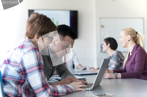 Image of young business couple working on laptop, businesspeople group on