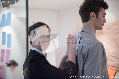 Image of young couple signing contract documents on partners back