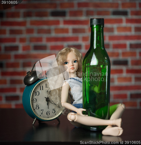 Image of doll with a bottle. the concept of alcoholism