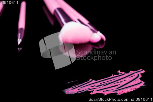 Image of lipstick with a brush make-up on black 