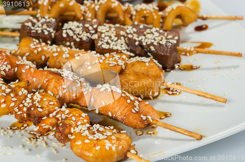 Image of Grilled juicy skewered shashlik on a plate, sesame