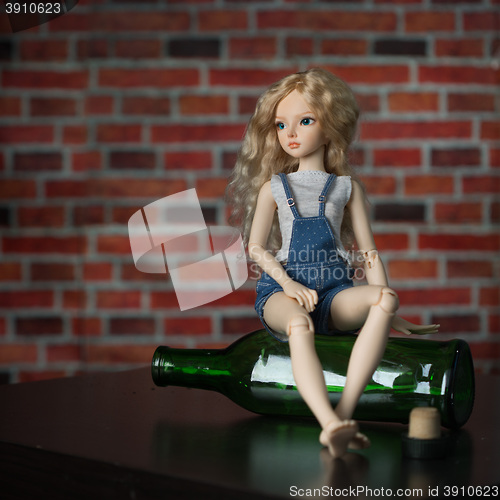 Image of doll with a bottle. the concept of alcoholism