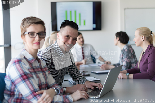 Image of young business couple working on laptop, businesspeople group on