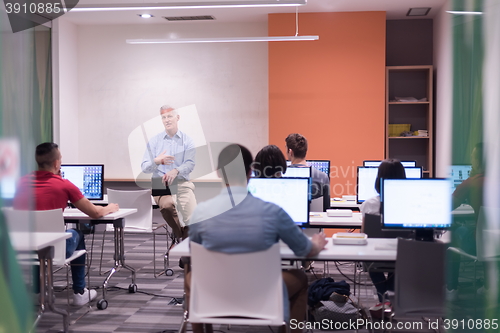 Image of teacher and students in computer lab classroom