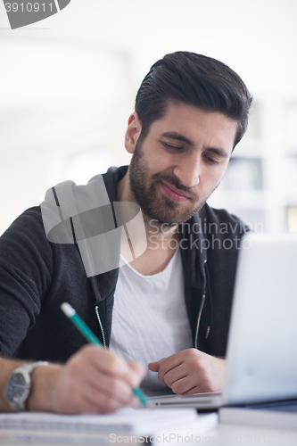 Image of student in school library using laptop for research