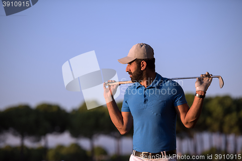 Image of golfer  portrait at golf course on sunset