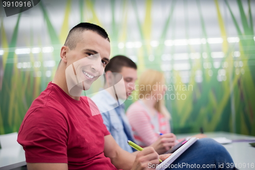 Image of male student taking notes in classroom