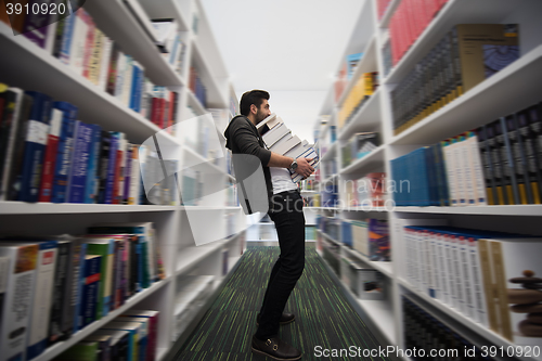 Image of Student holding lot of books in school library