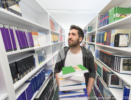 Image of Student holding lot of books in school library